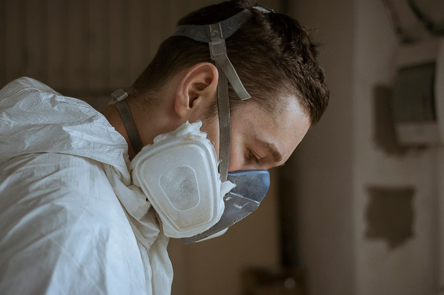Technician in protective coveralls and a respirator