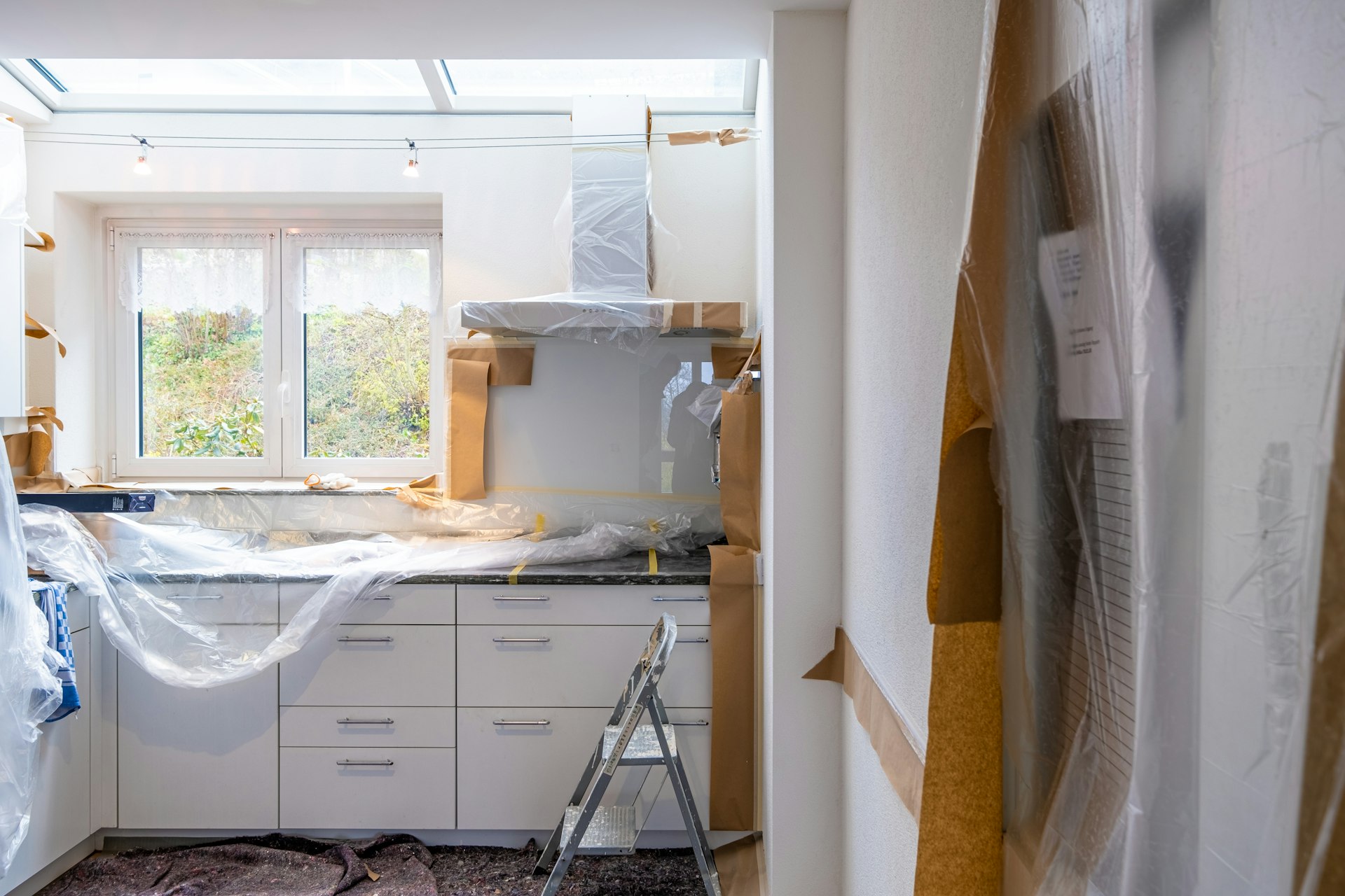 Home contents and cabinetry protected with plastic sheeting during restoration work