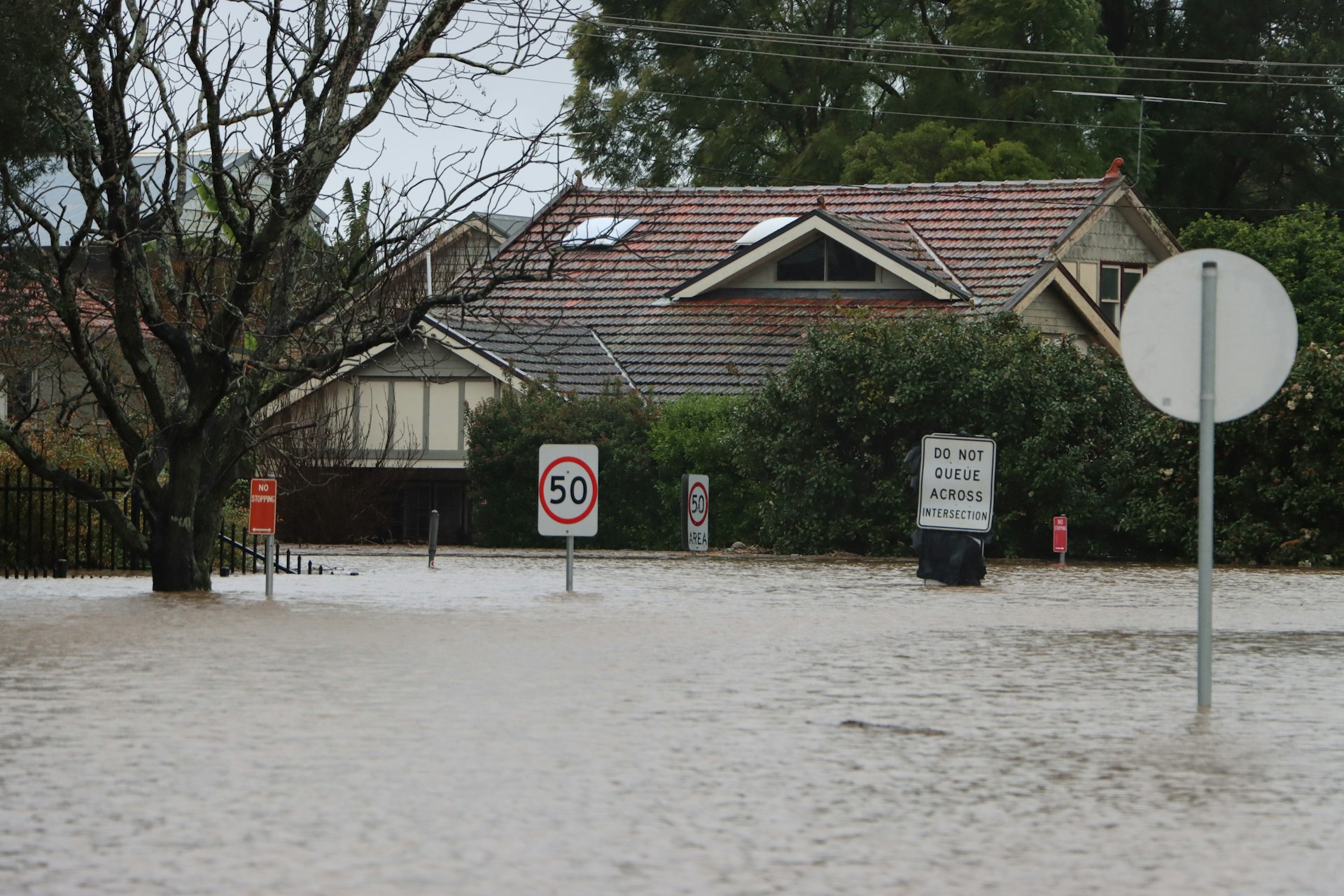 Floodwater surrounding homes on a residential street after a heavy storm